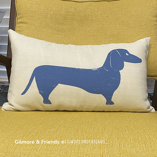 Gilmore and Friends blue dachshund pillow sitting on a yellow jens risom chair
